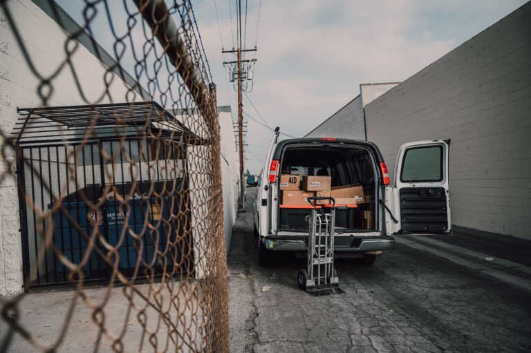 A long-distance moving truck being loaded outside a home